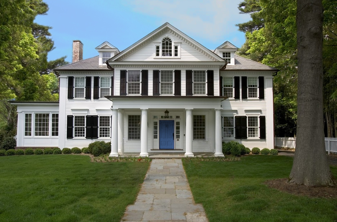 A large white house with blue door and windows.