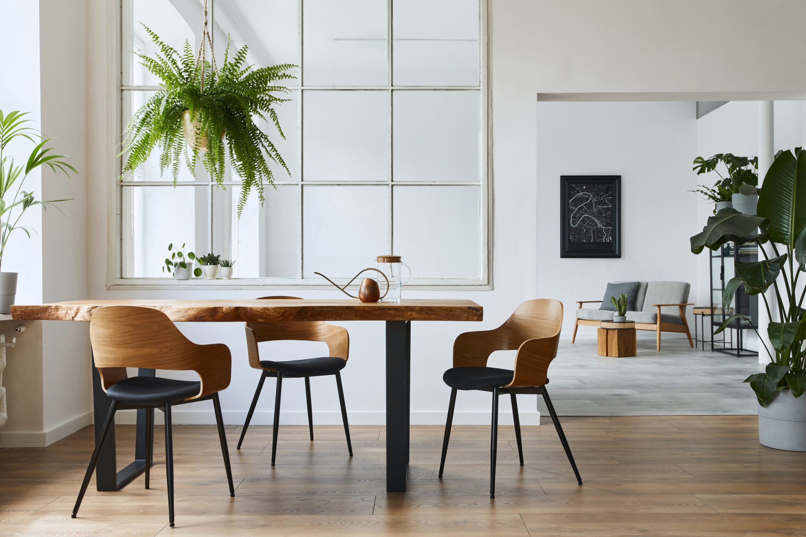 A dining room table with four chairs and a plant.
